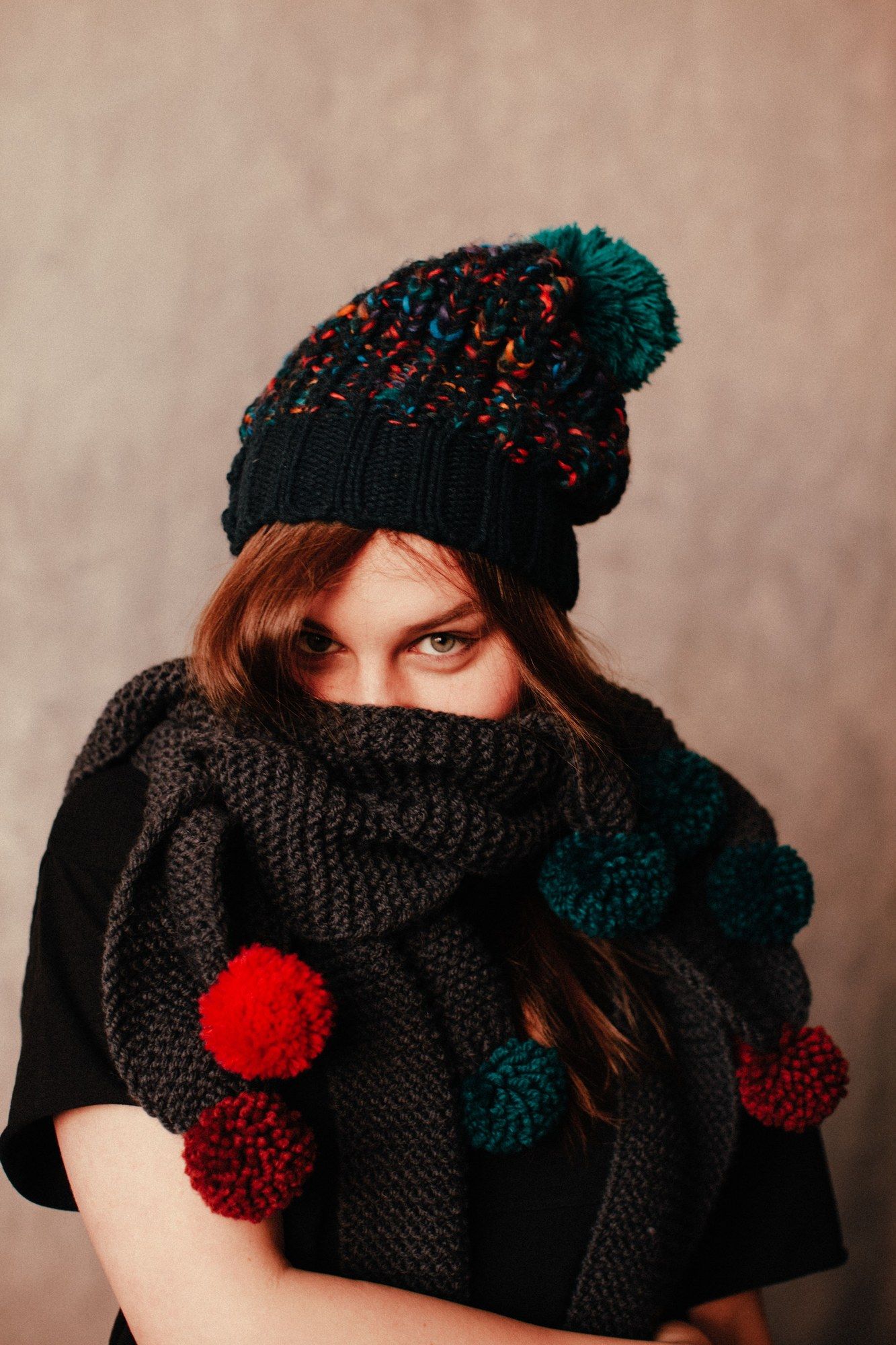 Mujer joven con gorro y bufanda de colores vivos