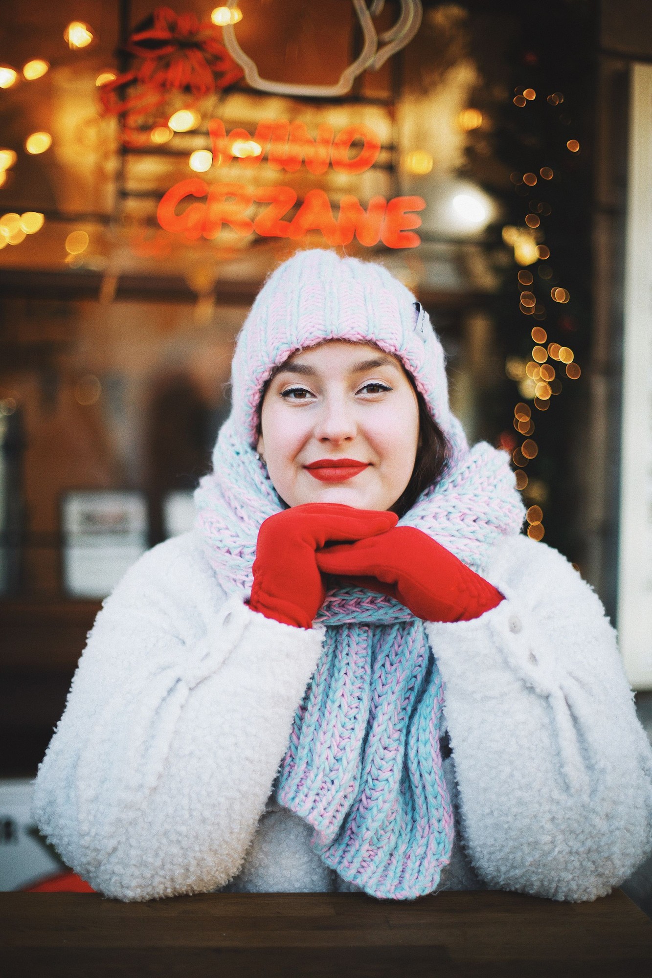 Mujer sonriente con ropa de invierno frente a un café