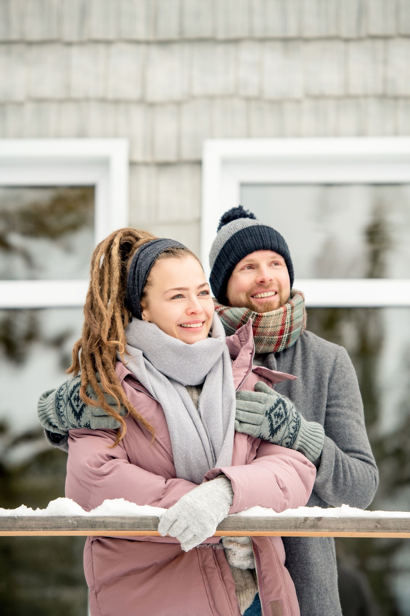 Pareja sonriente con ropa de abrigo en un día de nieve